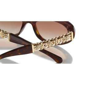Chanel sunglasses in tortoiseshell with gold-tone chain temple detail engraved with CHANEL lettering, brown gradient lenses