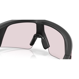 Close-up of sport wraparound sunglasses with matte black frame and pink-tinted shield lens, showing nose bridge detail