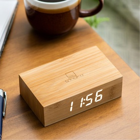 Gingko rectangular wooden alarm clock displaying 11:56 in white LED digits, styled on wooden desk with coffee cup