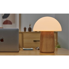 Gingko mushroom lamp with glowing white dome shade and wood-effect base, styled on a desk beside a laptop