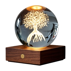 Gingko crystal ball lamp with illuminated tree design, warm amber glow, on a dark walnut wooden base with gold button detail