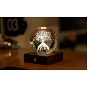 Gingko crystal ball light with illuminated tree design on dark wood base, warm LED glow, styled on a desk