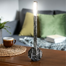Gingko Black Marble table lamp with slim LED strip top and round marble base, styled on a wooden surface with sofa in background