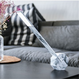 Gingko White Marble desk lamp with geometric stone base and slim angled arm, styled on a dark table in a living room setting