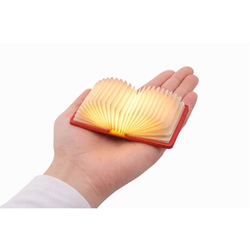 Gingko Mini Smart Book Light in Coral Red, glowing warm amber, shown open and fanned in a hand to indicate compact size