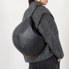 Model carrying Isabel Marant Oksan Hobo Shoulder Bag in black grained leather with gold-tone stud trim detailing, worn over grey textured coat.