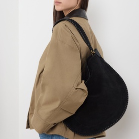 Model carrying Isabel Marant Oksan Hobo Shoulder Bag in black suede with braided trim and gold-tone hardware, styled with a tan jacket.