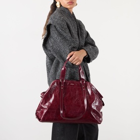 Model carrying Isabel Marant Winna Tote Bag in burgundy leather, silver-tone hardware, slouchy silhouette with carry handles, styled with grey knit