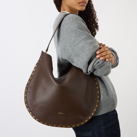Model carrying Isabel Marant Oksan Hobo Shoulder Bag in coffee grained leather with gold-tone stud trim detailing, worn over shoulder
