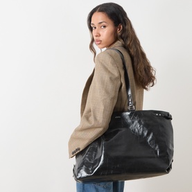 Model carrying Isabel Marant Winna Tote Bag in black textured leather, silver-tone hardware, slouchy silhouette, styled with a camel blazer