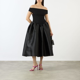 Model wearing Marques Almeida Mikado Princess Dress in black, off-shoulder fitted bodice with voluminous midi puff skirt, styled with pink heels and