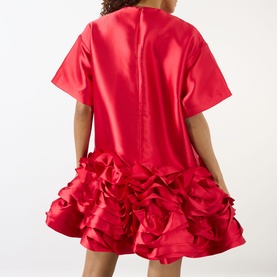 Model wearing Marques Almeida red dress, back view, short sleeves, voluminous ruffled hem skirt in satin-finish polyester fabric.