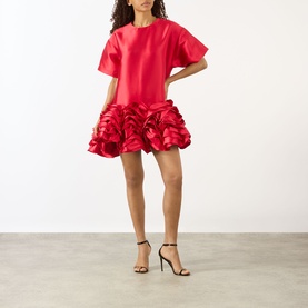 Model wearing Marques Almeida red mini dress with voluminous ruffle skirt and oversized T-shirt bodice, styled with black strappy heels
