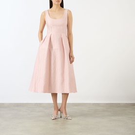 Model wearing Marques Almeida Pink Textured Brocade Dress with scoop neckline, sleeveless midi silhouette and pleated skirt, styled with silver heels.