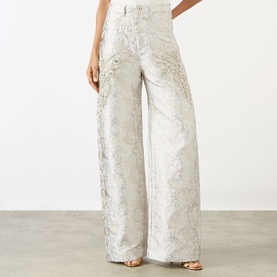 Model wearing Marques Almeida white wide-leg jeans with floral jacquard pattern and embellished detailing, high-rise fit