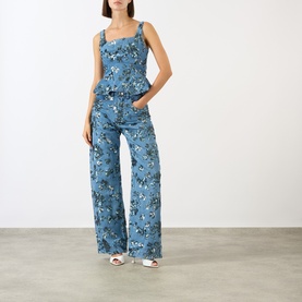 Model wearing Marques Almeida Sequin Embroidered Boyfriend Jeans in mid blue with floral embroidery, styled with matching cami top and white heels.
