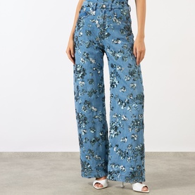 Model wearing Marques Almeida Sequin Embroidered Boyfriend Jeans in mid blue with floral sequin embroidery, high-rise wide-leg fit, styled with white