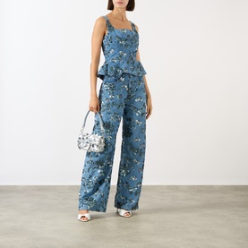 Model wearing Marques Almeida Mid Blue Sequin Embroidered Boyfriend Jeans, wide-leg fit, styled with matching peplum top and silver mini bag.