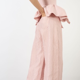 Model wearing Marques Almeida Pink Textured Brocade Boyfriend Jeans, wide-cut leg with ruffle waist detail visible at back