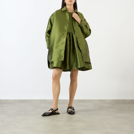 Model wearing Marques Almeida Heavy Fluid Shirt in khaki heavyweight satin, longline with dipped hem, styled with matching mini dress and black
