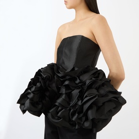 Model wearing Marques Almeida Ruffle Bustier Top in black, with strapless fitted bodice and voluminous ruffled ribbon peplum hem in heavy satin