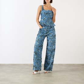 Model wearing Marques Almeida Mid Blue Sequin Embroidered Denim Peplum Top with matching wide-leg floral denim trousers and white mule heels.