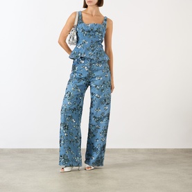 Model wearing Marques Almeida Sequin Embroidered Denim Peplum Top in mid blue, styled with matching wide-leg floral denim trousers and silver heels.