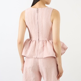 Model wearing Marques Almeida Textured Brocade Peplum Corset Top in pink, back view showing zip fastening and peplum hemline, styled with matching