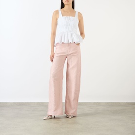 Model wearing Marques Almeida Wrinkled Gathered Top in white with square neck, peplum hem, styled with pink wide-leg jeans and metallic sandals.