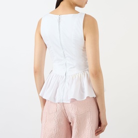 Model wearing Marques Almeida Wrinkled Gathered Top in white, showing back zip, peplum hemline and shirred detail, styled with pink trousers.