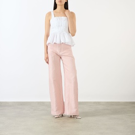 Model wearing Marques Almeida Wrinkled Gathered Top in white with square neck and peplum hem, styled with pink wide-leg trousers.