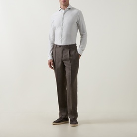 Model wearing Profuomo Dark Green Single Cuff Regular shirt with brown pleated trousers and grey trainers.