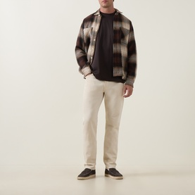 Model wearing Profuomo Solid Logo Pima T-Shirt in brown, styled with check overshirt and cream trousers, dark trainers.
