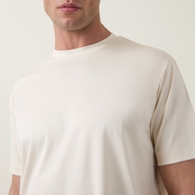 Model wearing Profuomo Solid Logo Pima T-Shirt in Raw White, crew neck, short sleeves, relaxed fit, 100% cotton.