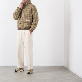 Model wearing Storefront Script Logo Flannel Utility Jacket in green check print, styled with cream wide-leg trousers and chunky trainers.