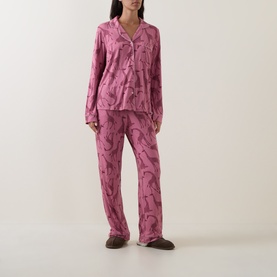 Model wearing Chelsea Peers Modal Giraffe Long Pyjama Set in Giraffe Pink, two-piece with long sleeves, revere collar and wide-leg trousers