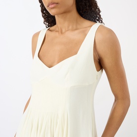 Model wearing JW Anderson ivory sleeveless dress with V-neckline and pleated skirt detail, in viscose-linen blend