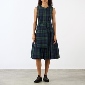 Model wearing JW Anderson navy and green tartan cotton dress, sleeveless with cinched waist and tiered midi skirt, styled with black loafers