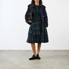 Model wearing JW Anderson Navy/Green tartan cotton dress with navy trench coat, carrying black bag, styled with black lace-up shoes.