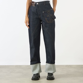 Model wearing JW Anderson Twisted Wide Leg Trousers in indigo, with anchor logo stitching, wide leg fit and turned-up hem. Styled with black chunky