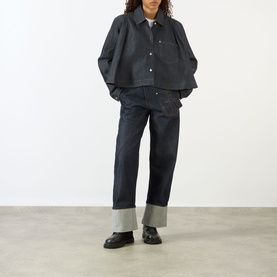 Model wearing JW Anderson Twisted Wide Leg Trousers in Indigo 870, wide leg with turned-up hem, styled with a dark denim jacket and black loafers.