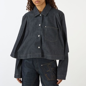 Model wearing JW Anderson Flare Hem Denim Shirt in indigo with flared silhouette, chest pocket, and button fastenings, styled with matching indigo