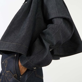 Model wearing JW Anderson Flare Slim Denim Shirt in indigo, showing dramatic flared sleeves, styled with matching indigo jeans.