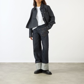 Model wearing JW Anderson Anchor Logo T-Shirt in White 001, styled with dark indigo cuffed wide-leg jeans and a denim jacket.