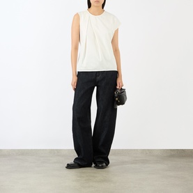 Model wearing JW Anderson ivory sleeveless cotton top with ruched shoulder detail, styled with black wide-leg trousers and mini bag.