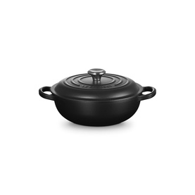 Le Creuset Matte Black cast iron casserole dish with domed lid, dual handles, and a wide shallow profile.