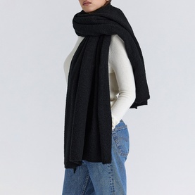 Model wearing House of CB Ivory scarf, styled with cream ribbed top and blue jeans. Large wrap style with frayed edges.