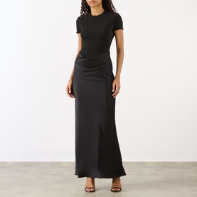 Model wearing Rotate black maxi dress with short sleeves, ruched waist detail and side split, styled with black heels.