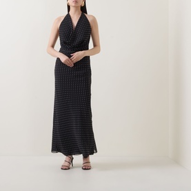 Model wearing Rotate black combination halterneck maxi dress with polka dot print, styled with strappy heeled sandals