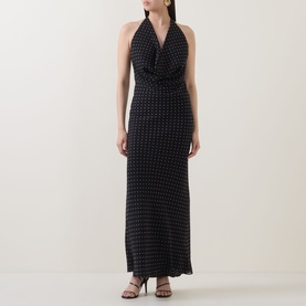 Model wearing Rotate black halterneck maxi dress with all-over dot print, cowl neckline, and fitted silhouette, styled with strappy heels